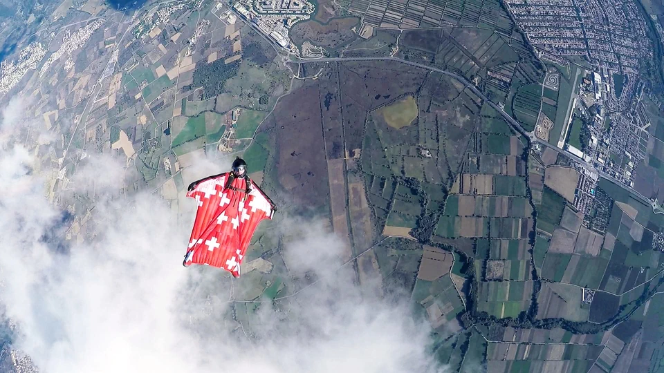 Daniel Ossio in wingsuit flight over Swiss landscape